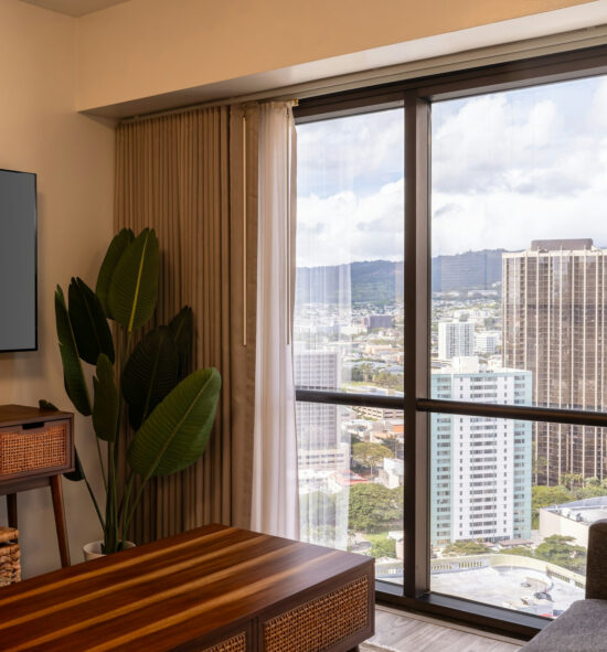 Glass windows show off the Honolulu skyline with indoor furnishings